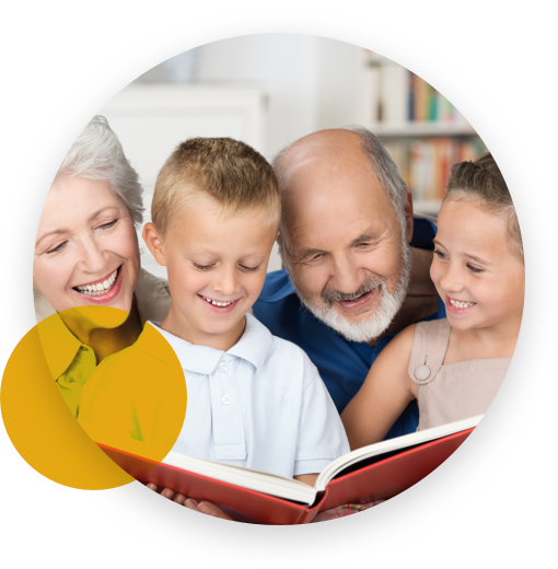 Grandparents happily reading a book with their grandchildren