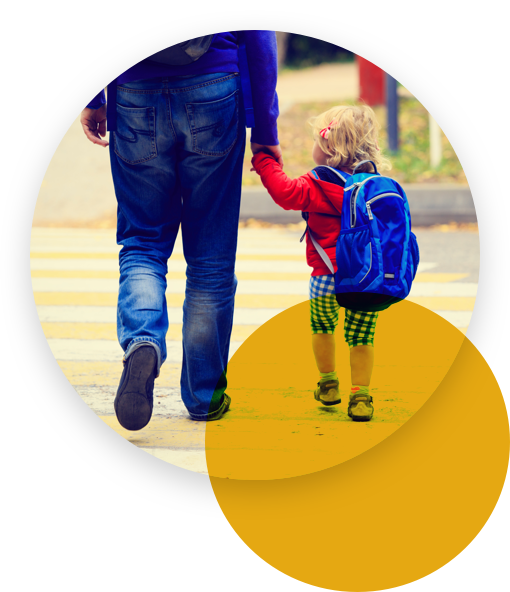 Man holding a toddler crossing the street