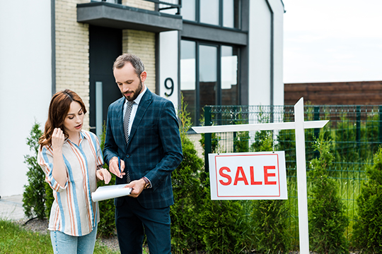 Real estate agent explaining some documents to a woman