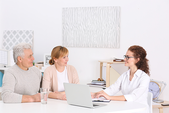 Senior couple happily talking to a doctor