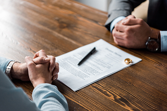 Man and woman with papers and gold rings in between them